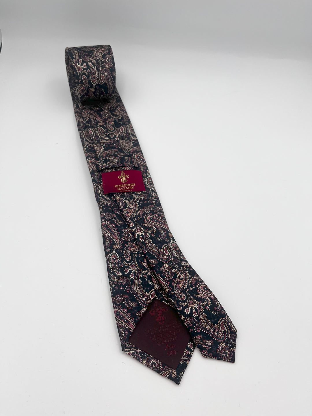 Sort silkeslips med brun og beige paisley, lagt i en løs knude