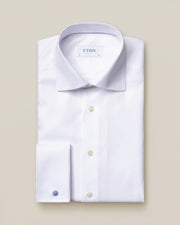 en klassisk herreskjorte med god spedning på skjortekraven. knapperne har dét dét perlemors skær, og dobbeltmanchetten kan du se på dette billede, tv. med den blå manchetknap